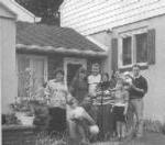 波斯尼亚一家人在一所房子外的黑白照片.