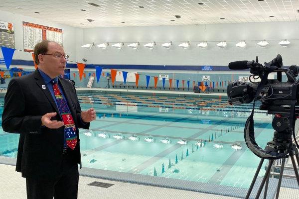 保罗·麦克阿瑟教授站在加州大学游泳池旁边讨论奥运会.